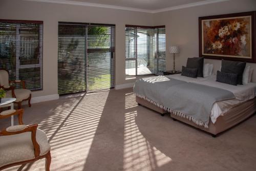 a bedroom with a large bed and some windows at Sunset Haven in Knysna