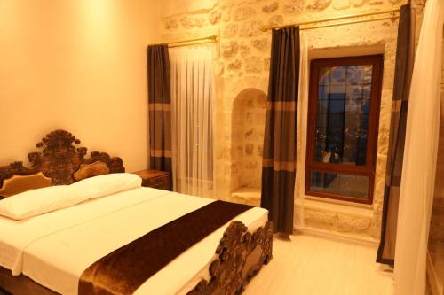 um quarto com uma cama e uma janela em Mardin Bey Konağı Hotel em Mardin