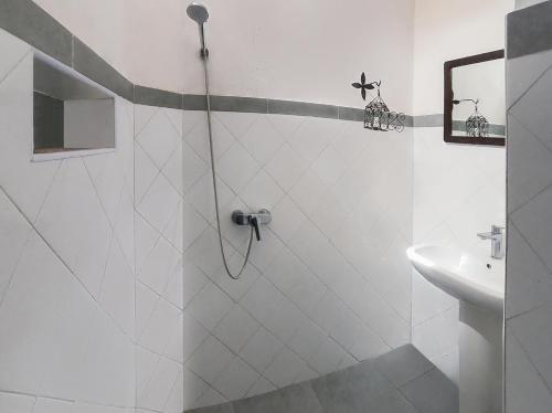 La salle de bains blanche est pourvue d'une douche et d'un lavabo. dans l'établissement Hotel-Restaurant Le Kaouki, à Sidi Kaouki