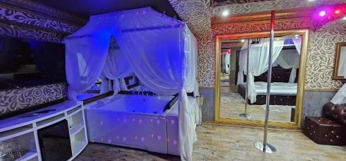 a purple room with a bed and a mirror at Hotel Boutique Mikaela (Adult Only) in Braşov