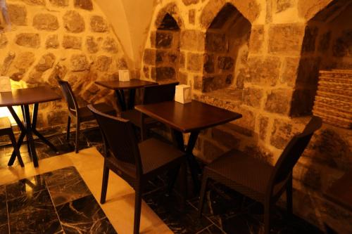 a restaurant with tables and chairs in a stone wall at Mardin Bey Konağı Hotel in Mardin
