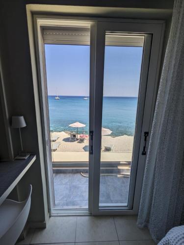 a bathroom with a view of the ocean from a window at Pillbox Seafront Studios and Apartments in Kardamaina