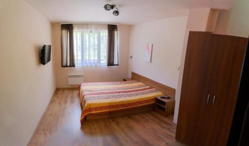 ein kleines Schlafzimmer mit einem Bett und einem Fenster in der Unterkunft Апартамент Езерото in Trjawna