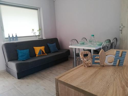 uma sala de estar com um sofá e uma mesa em Lazurowy Zakątek em Dąbki