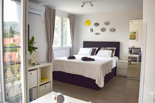 1 dormitorio con 1 cama grande y balcón en Studio Apartments Anija, en Dubrovnik