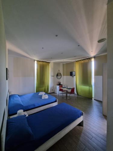 リド・ディ・オスティアにあるMy Room Romaのベッド2台とテーブルが備わる客室です。