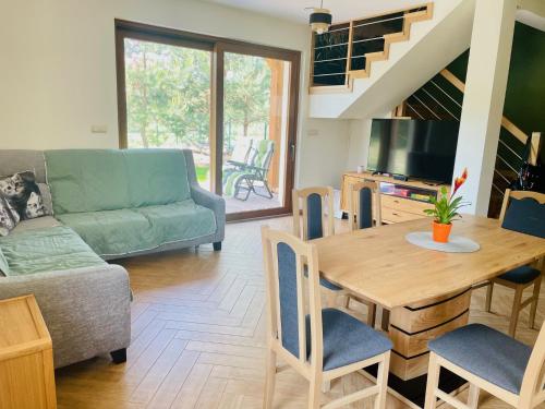 a living room with a couch and a table with chairs at Mazurska Sarenka in Wiartel