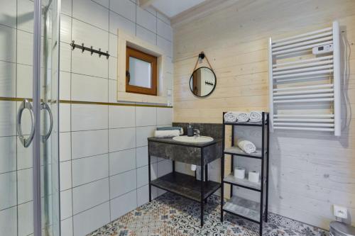 a bathroom with a sink and a mirror at Omega Niechorze Domki Letniskowe in Niechorze