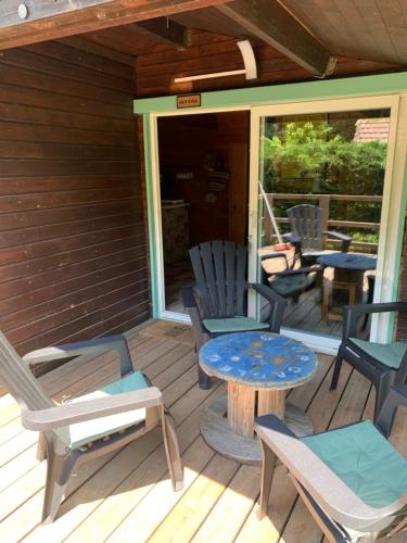 a deck with chairs and a table and chairs at les petits chalets de DUDU in La Voulte-sur-Rhône