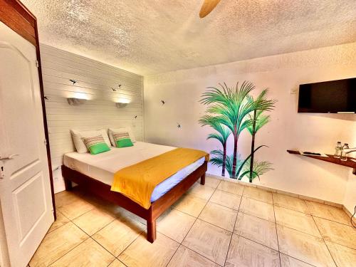 a bedroom with a bed and a plant on the wall at Hôtel Résidence Océane in Tartane