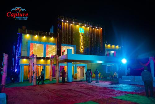 um grupo de pessoas em pé fora de um edifício à noite em The Nirvana Resort em Chatra