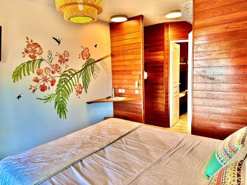 a bedroom with a bed with a flower mural on the wall at Hôtel Résidence Océane in Tartane