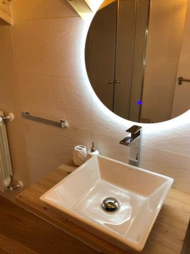 a bathroom with a white sink and a mirror at Apartamentos El Arroyo in Armal