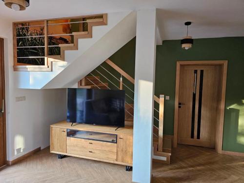 a living room with a tv and a staircase at Mazurska Sarenka in Wiartel