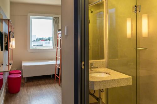 a bathroom with a shower and a sink and a tub at ibis budget Foz do Iguaçu in Foz do Iguaçu