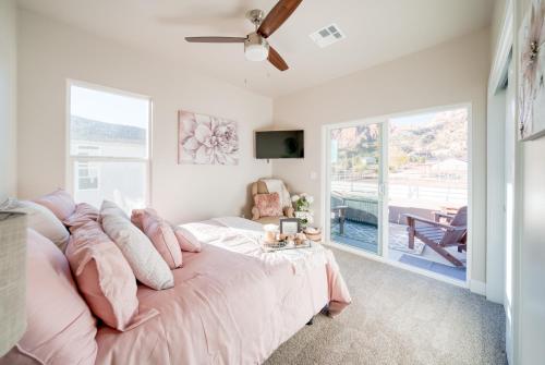 a bedroom with a large bed with pink pillows at New South Zion Coral Cliffs - 4 bed, 3 bath, hot tub, deck in Hildale