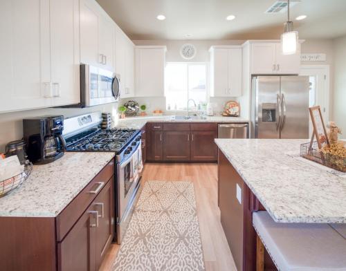 a kitchen with white cabinets and a stove top oven at South Zion Coral Cliffs - 4 bed, 3 bath, hot tub, deck in Hildale