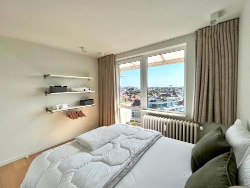 a bedroom with a bed and a large window at Viviane - Beautifull view, Garage, 200m from beach in De Panne