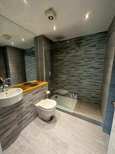 a bathroom with a toilet and a sink and a tub at Bond Street Luxury Apartment Central Chelmsford in Chelmsford