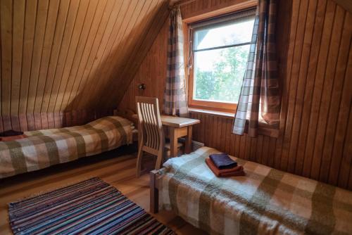 a room with two beds and a table and a window at Pruuli Holiday Farm in Sõru