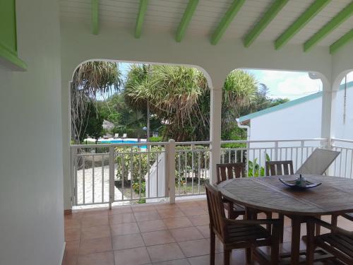 a patio with a table and chairs on a porch at Au Village de Menard in Saint-Louis