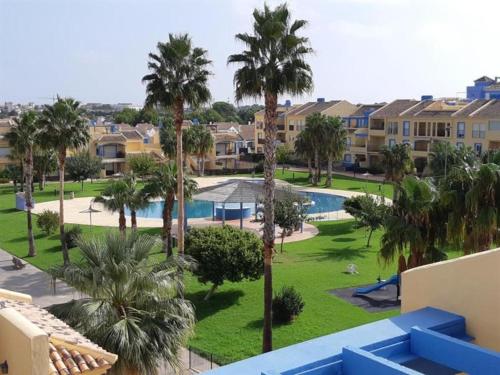 - une vue sur un complexe avec une piscine et des palmiers dans l'établissement appartement bord de mer 15 mn de Dénia, à El Verger