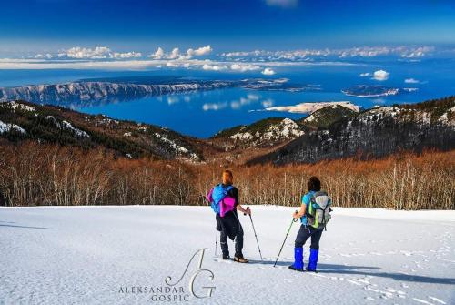 2 personnes à skis sur une piste enneigée dans l'établissement Apartman Legac, à Stari Grad