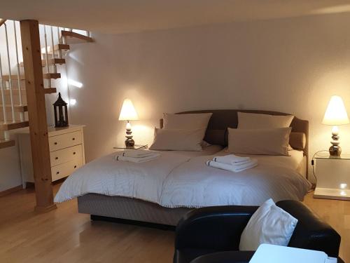 um quarto com uma cama com 2 candeeiros e uma cadeira em Radebeul mit Flair em Radebeul