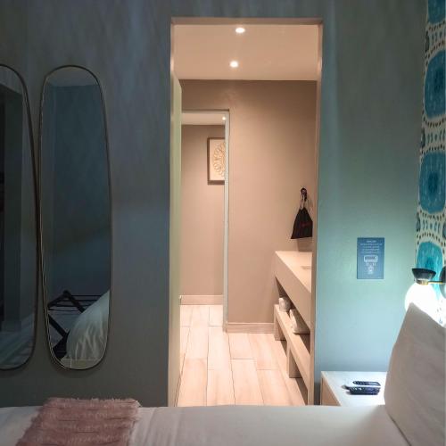 a bedroom with a bed and a large mirror at Trópica Beach Hotel in San Juan