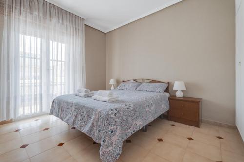 ラ・マタにあるPlaya la Mata - Apartamento "Limonka"の白いベッドルーム(ベッド1台、窓付)