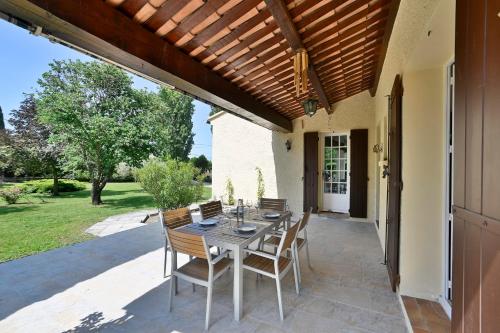 eine Terrasse mit einem Tisch und Stühlen auf einer Terrasse in der Unterkunft Villa Marie-Rose in Saint-Didier