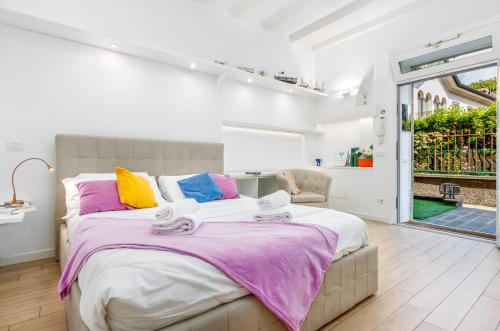 a bedroom with a large bed with colorful pillows at FEEL - Patio del Sole in Bergamo