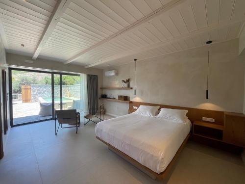 a bedroom with a large bed and a large window at Melitsina Village Hotel in Kardamyli