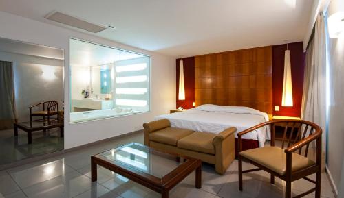 um quarto com uma cama, uma cadeira e uma mesa em Hotel Atlântico Copacabana no Rio de Janeiro