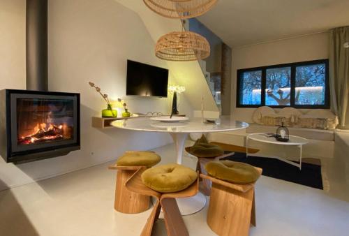 - un salon avec une cheminée, une table et des tabourets dans l'établissement Maison Alice&Eugène, à Montpellier