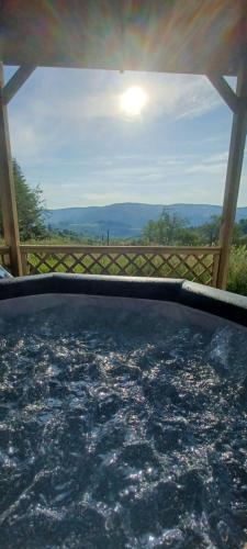a hot tub with a view of the mountains at Yourtissimo in Laprugne