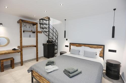 a bedroom with a bed with towels on a table at Stones By Syros Bnb in Ermoupoli