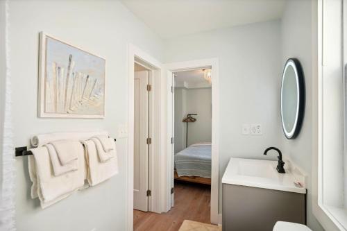ein weißes Badezimmer mit einem Waschbecken und einem Spiegel in der Unterkunft Twin Tiki 2 in St Pete Beach
