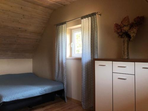 a small bedroom with a bed and a window at Mazurski domek in Mrągowo