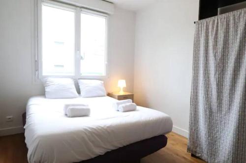 une chambre avec un lit blanc avec une fenêtre dans l'établissement T3 confort - proche du port, à Vannes