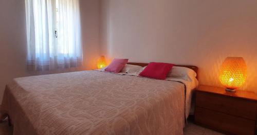 a bedroom with a bed with two lamps on it at Casa Lucia in Cala Gonone