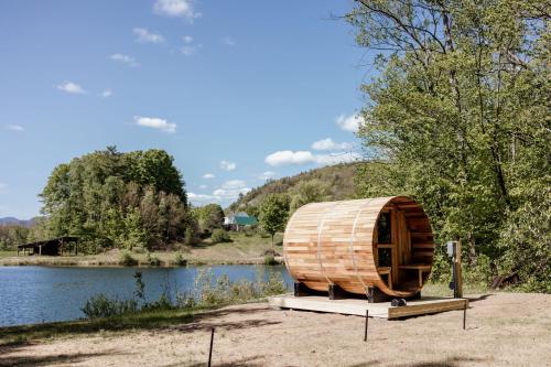 ein Holzfass neben einem Wasserkörper in der Unterkunft Lumen Nature Retreat in Woodstock