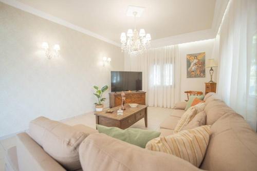 a living room with a couch and a television at Mulberry tree villa in Agios Nikolaos