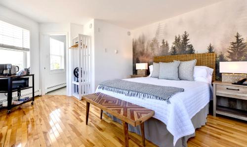 a bedroom with a large bed and a desk at North Star Beach Suites in Louisbourg