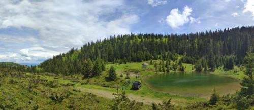 a large emerald lake in the middle of a mountain at KOLIBA Marijanović in Andrijevica