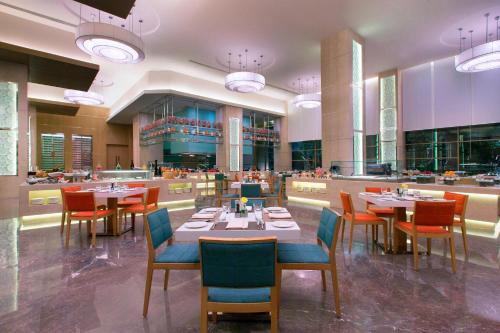 a dining room with tables and chairs in a restaurant at The Westin Chennai Velachery in Chennai