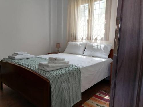 een slaapkamer met een bed met handdoeken erop bij EPavli Xenia Pefkochori-Paliouri 50m in Paliouri
