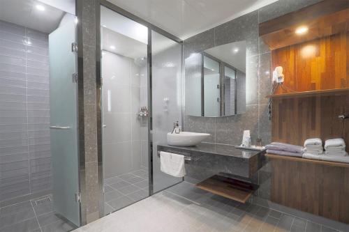 a bathroom with a sink and a shower at HOTEL YUNA Business in Busan