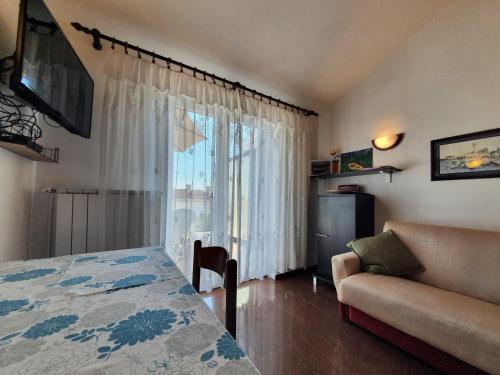 クルクにあるApartment with Terace and sea view Maricaのベッドとソファと窓のある部屋