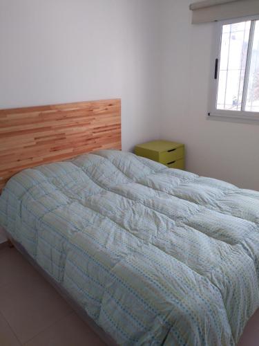 a bedroom with a bed with a blue comforter at Complejo TuLuz - Dpto 1 dormitorio con cochera y Monoambiente, con cochera opcional en Tolosa, La Plata, in Tolosa
